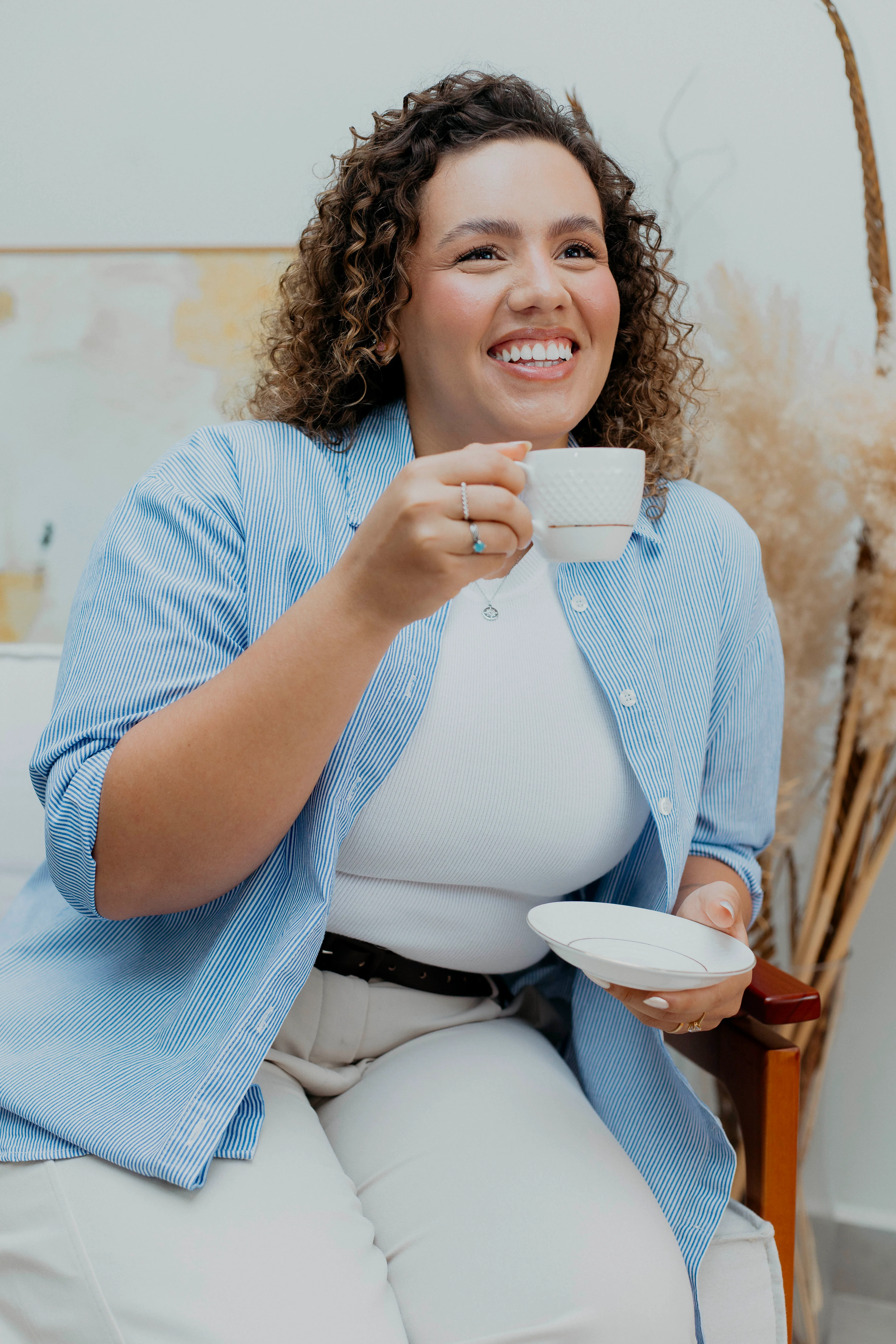Karine Maciel, psicóloga clínica, sorrindo com uma xícara de café